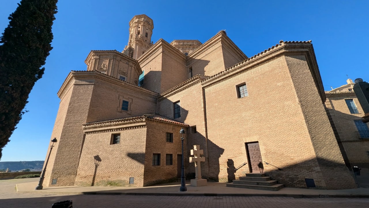 Iglesia de estilo arquitectónico antiguo con fachada de ladrillo y torre alta.