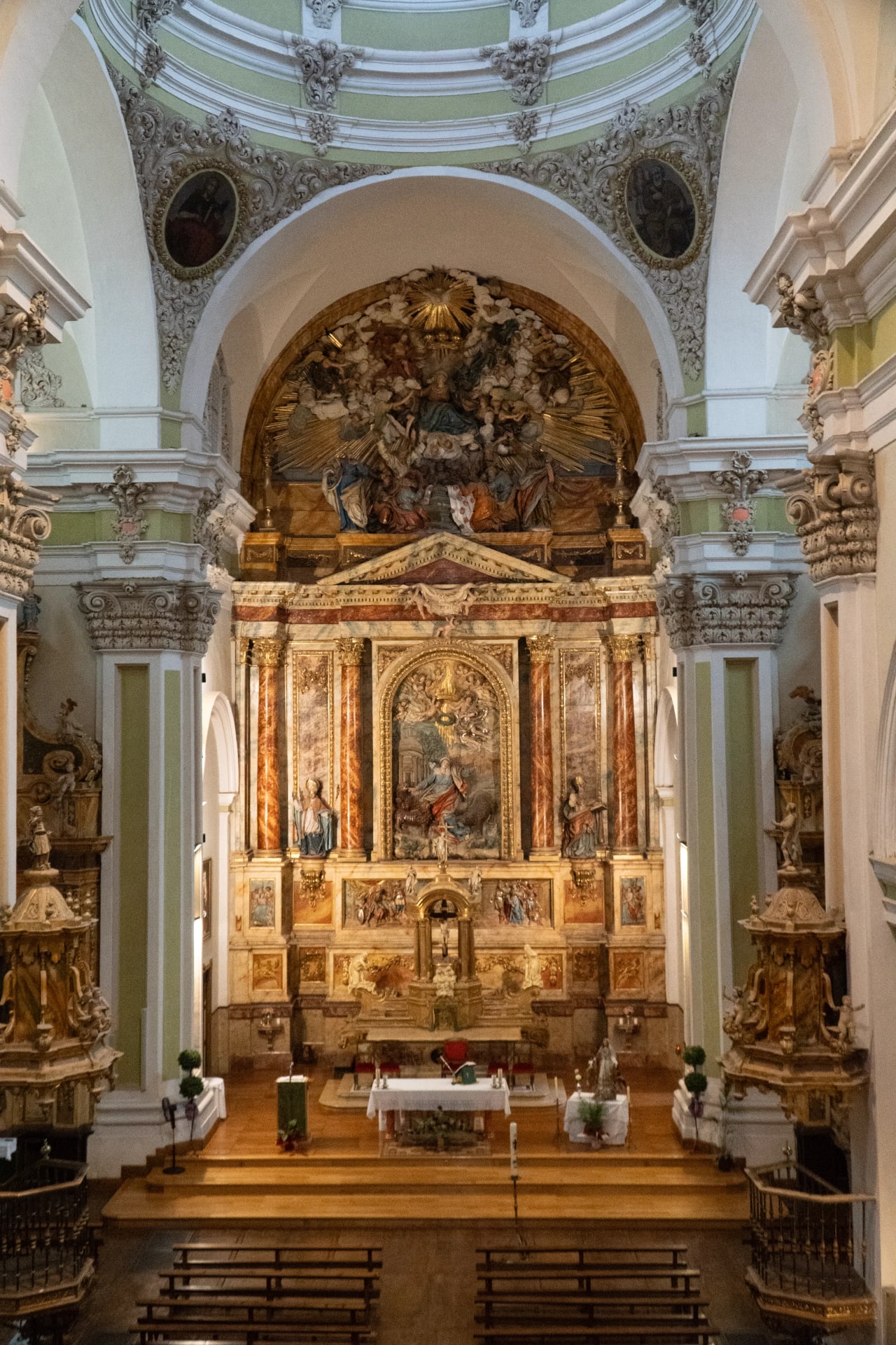 Interior de iglesia con altar barroco y decoración dorada.