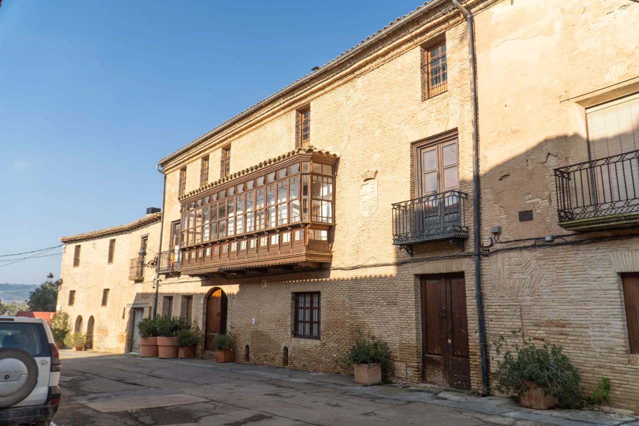 Casa grande con balcones de madera y escudo en la fachada