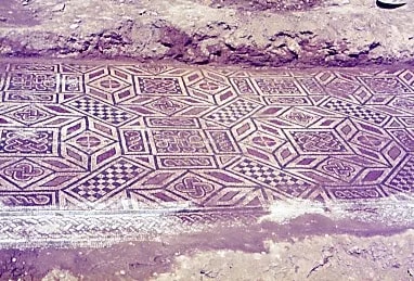 Mosaico antiguo con patrones geométricos en tonos ocres.