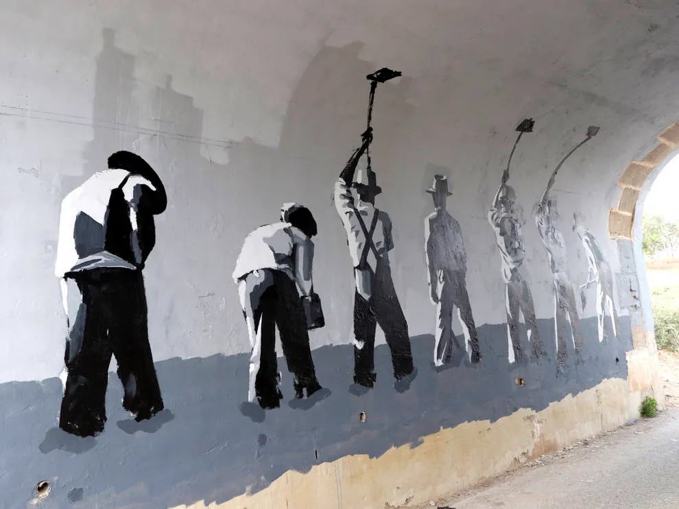 Mural de hombres en negro y blanco limpiando una pared.