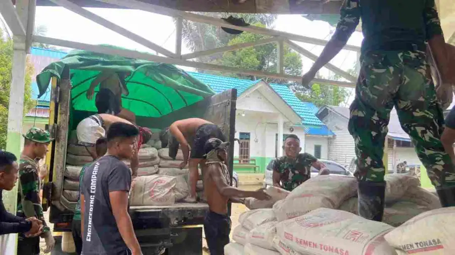 Anggota Satgas TMMD Wiltas ke-127 Kodim 0912/Kubar Turunkan Material Semen untuk Semenisasi Jalan di Linggang Amer