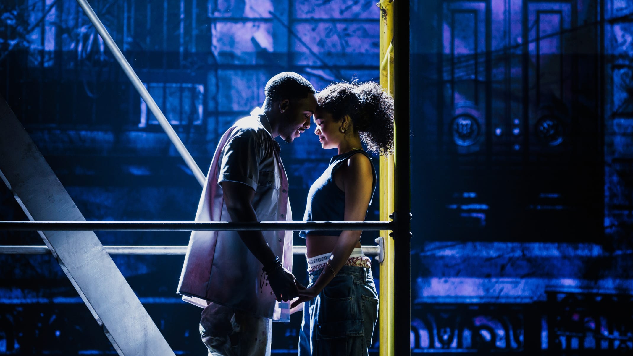 A young man and a young woman with their foreheads together having a romantic moment.