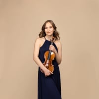 Photo of Geneva Lewis standing with her violin.