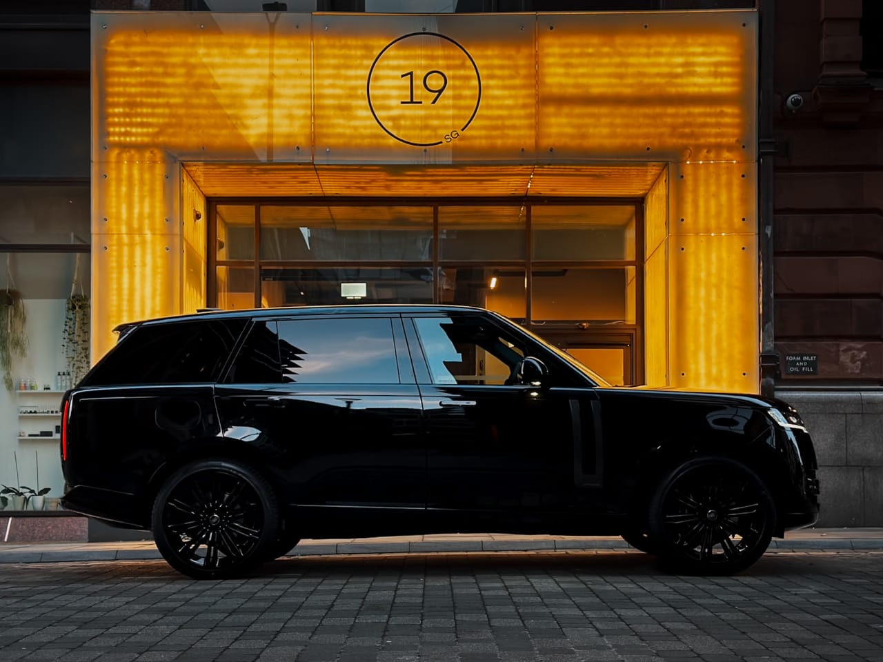 The Range Rover Autobiography outside a lit doorway at night