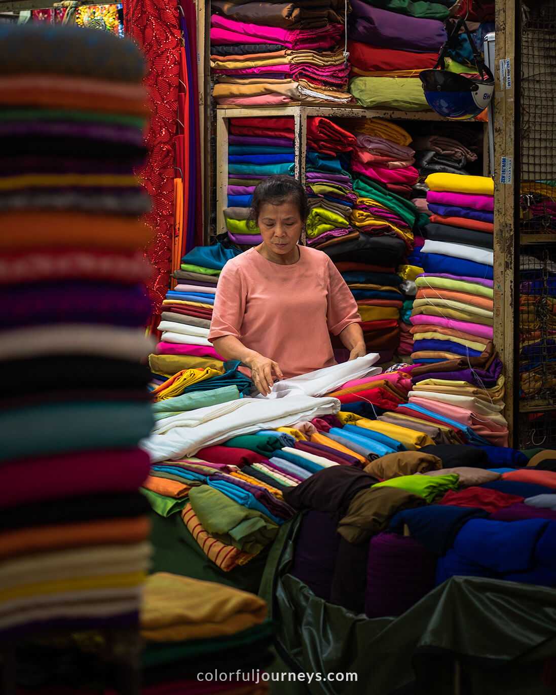 A woman sells linen at a market in Hanoi, Vietnam