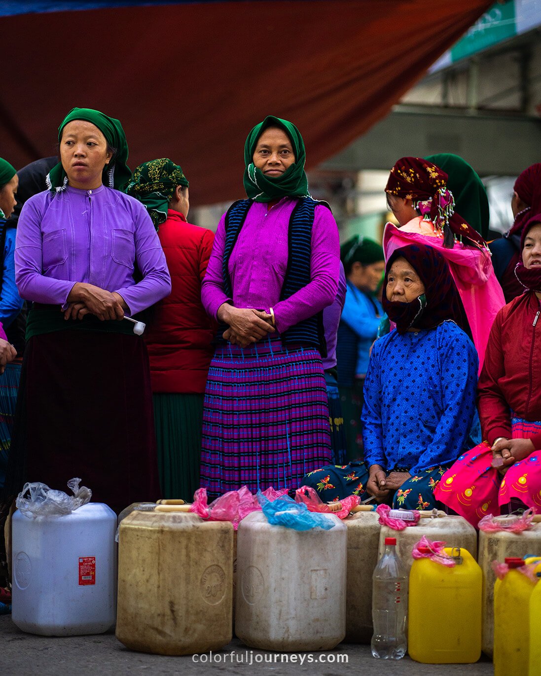 Women sell rice wine out of jerry-cans at Meo Vac Market, Vietnam