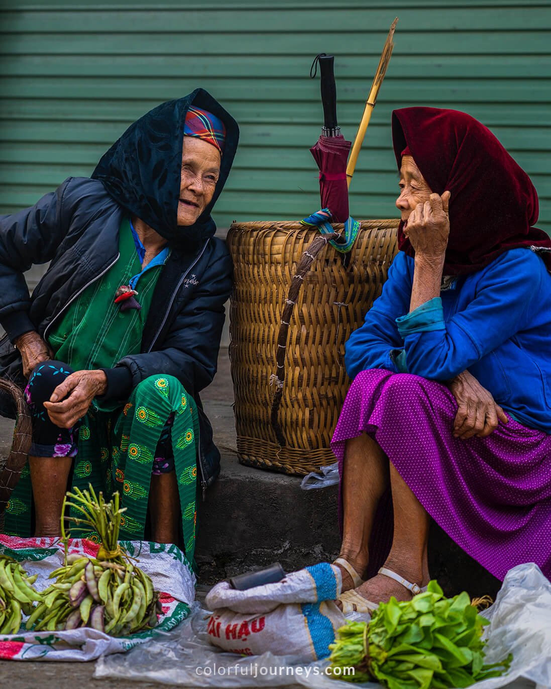 Two elderly women have a chat at Meo Vac Market, Vietnam