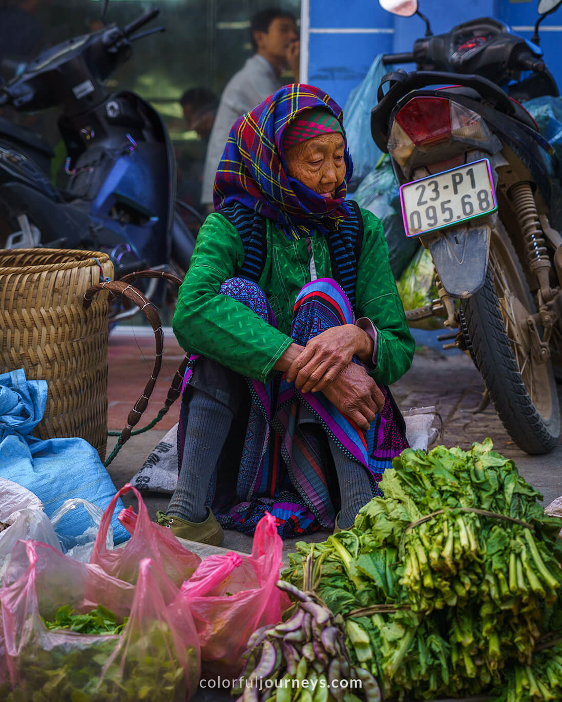 An elderly womans sells vegetables at Meo Vac Market, Vietnam