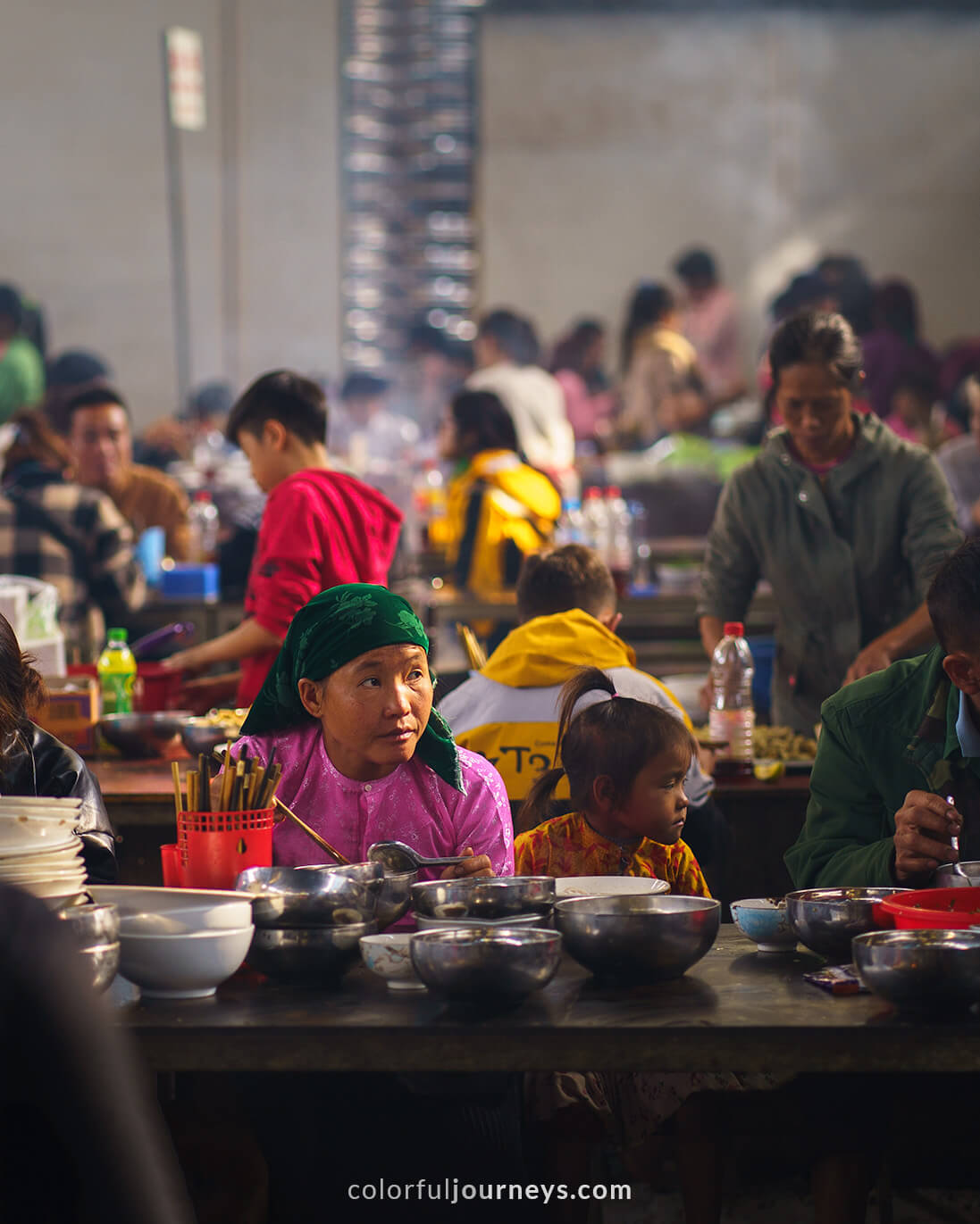 A woman eats noodles at Meo Vac Market, Vietnam