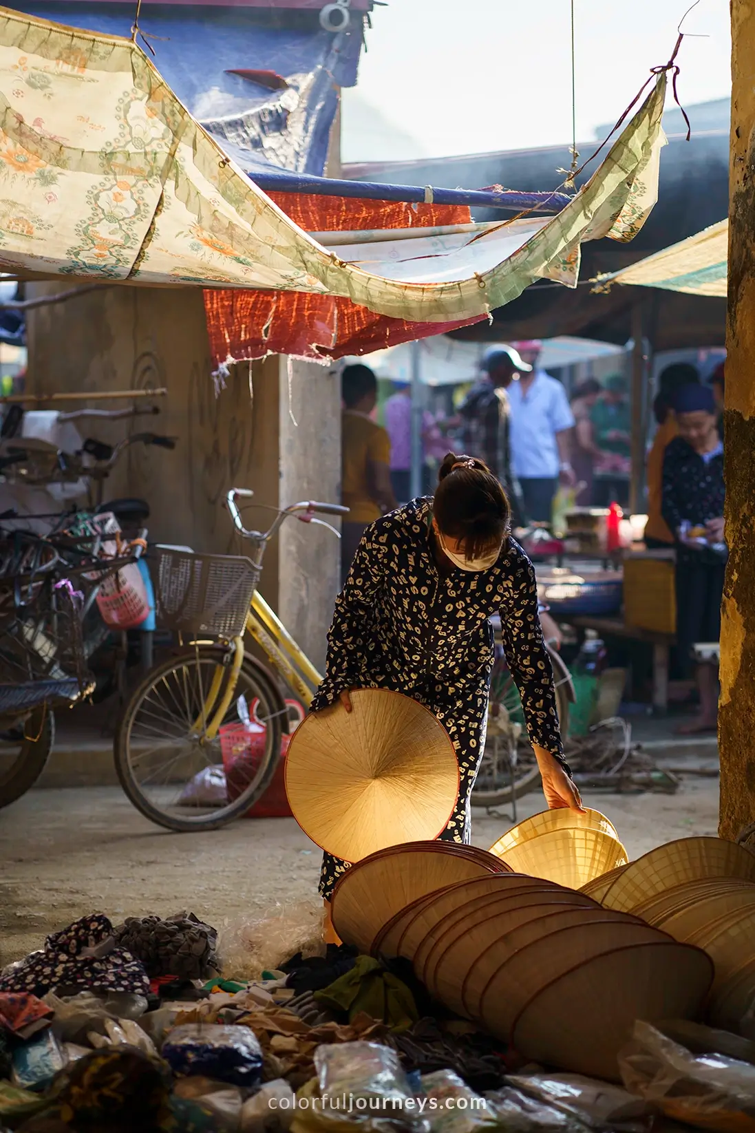 A woman buys a conical hat at a market in Pu Luong