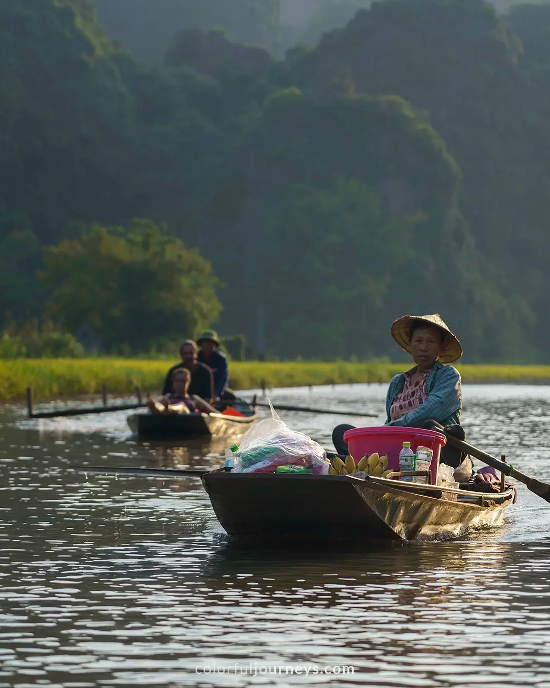 A vendor sells snacks from a boat in Tam Coc, Vietnam