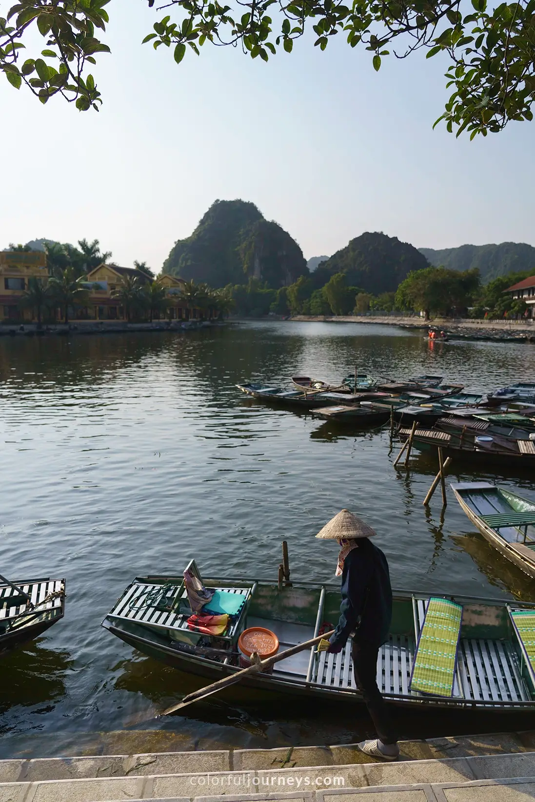 A woman wearing a Non La gets in her boat in Tam Coc, Vietnam