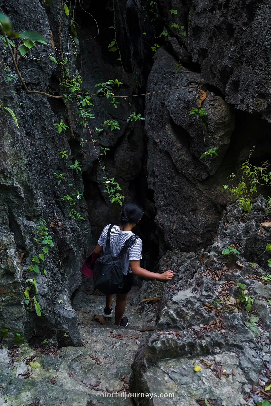 A woman decends narrow steps at a viewpoint in Tam Coc, Vietnam