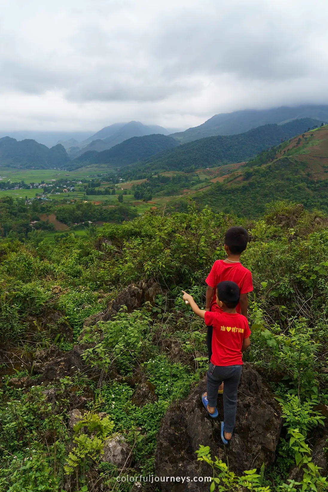 Two boys look into the valley of Tu Le, Vietnam