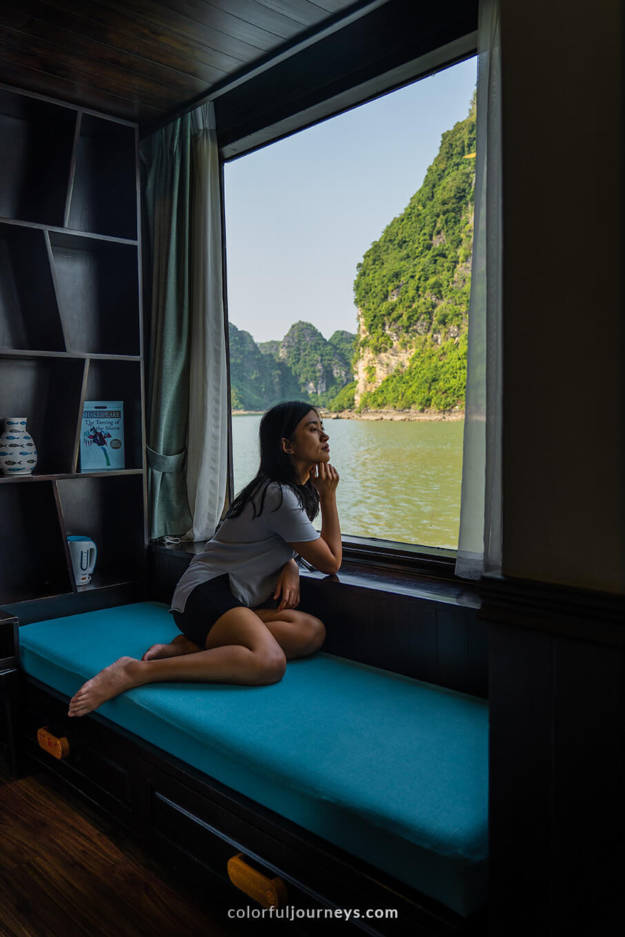 A woman looks out of the window of a cruise in Halong Bay, Vietnam