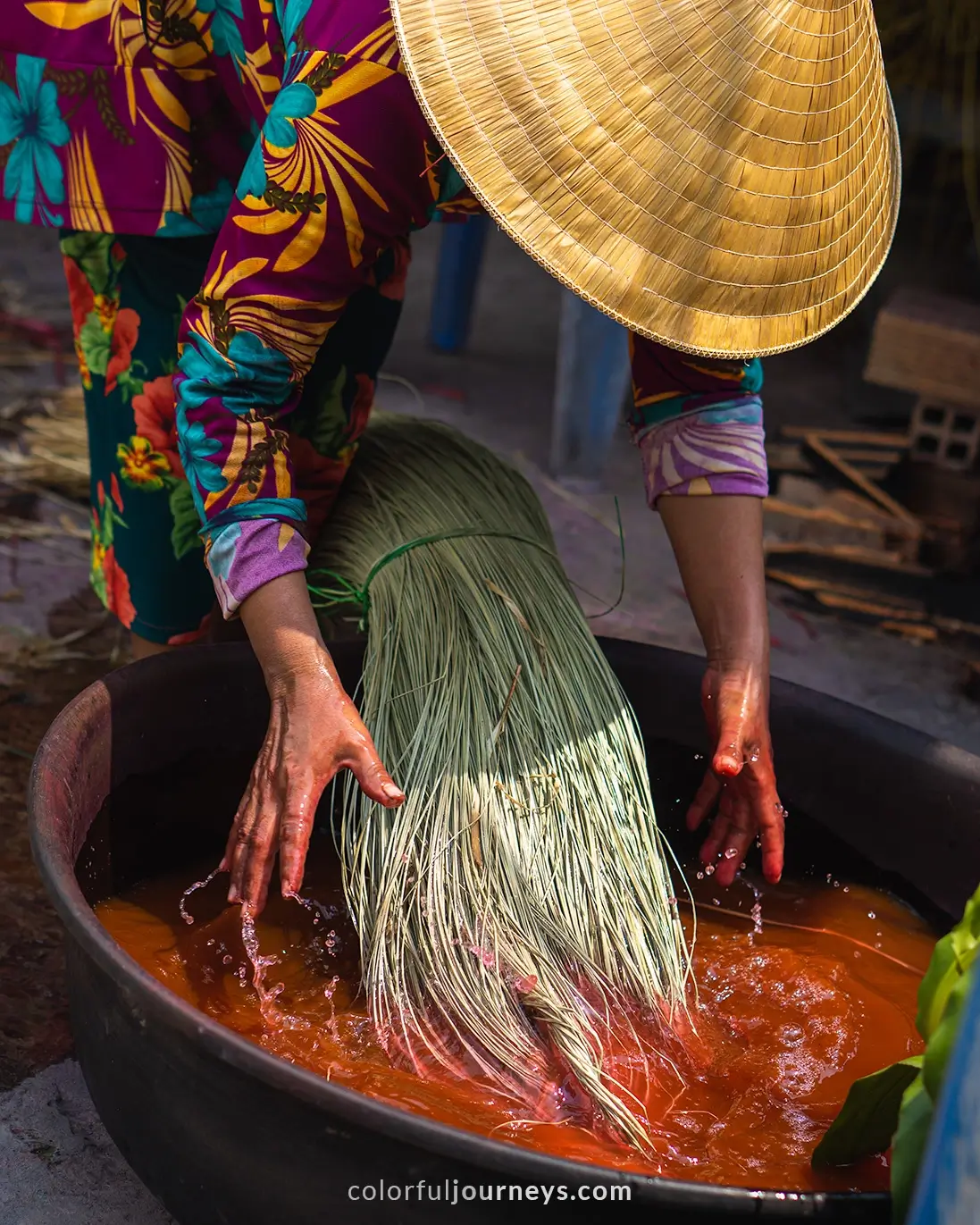 A woman dyes and weaves mats in Vietnam