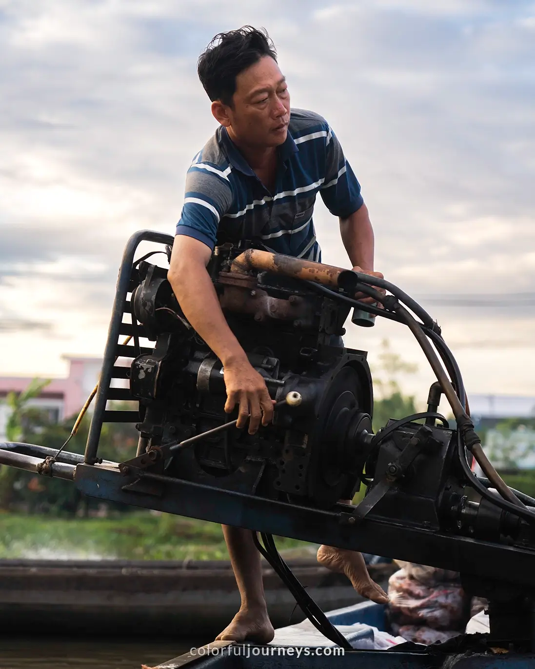 A man operating an engine on a boat in Vietnam