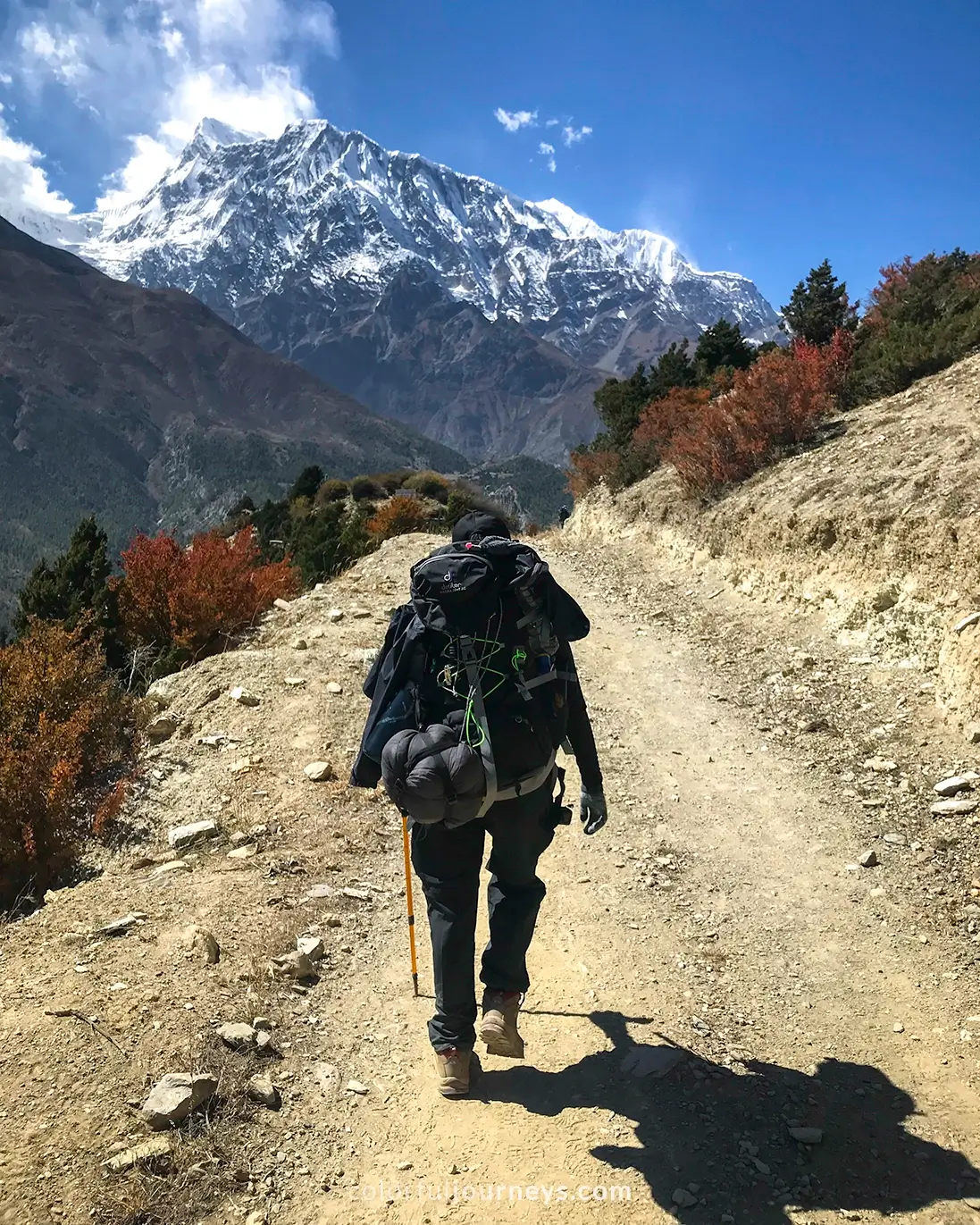 Mountains in Nepal with a woman walking on the trail