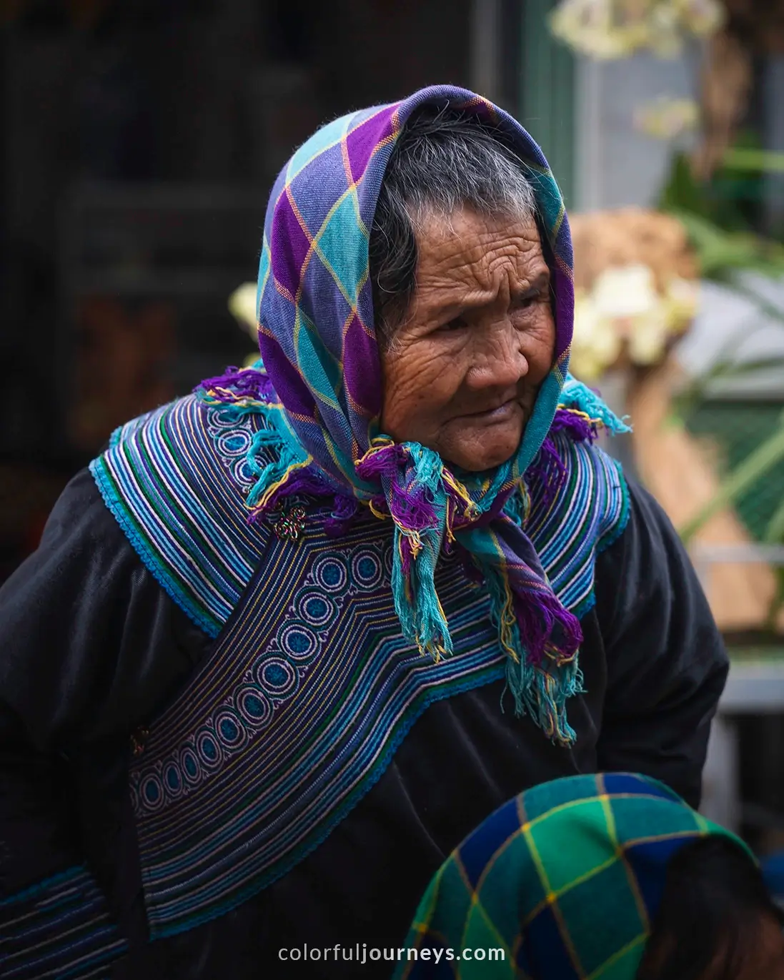 A woman wearing a colorful scarf at Bac Ha market, Vietnam