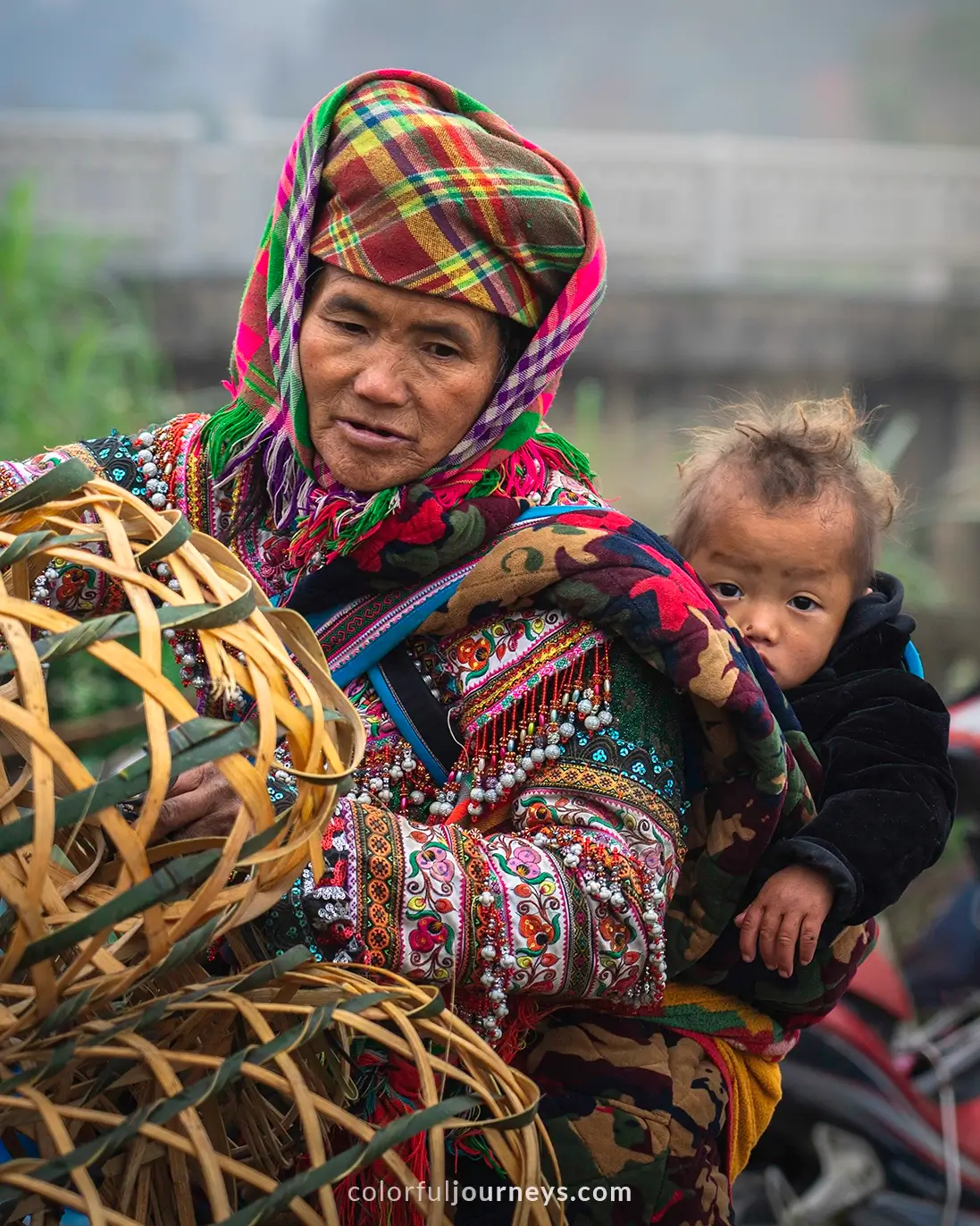 A woman carries her baby on her back while working at Bac Ha market, Vietnam