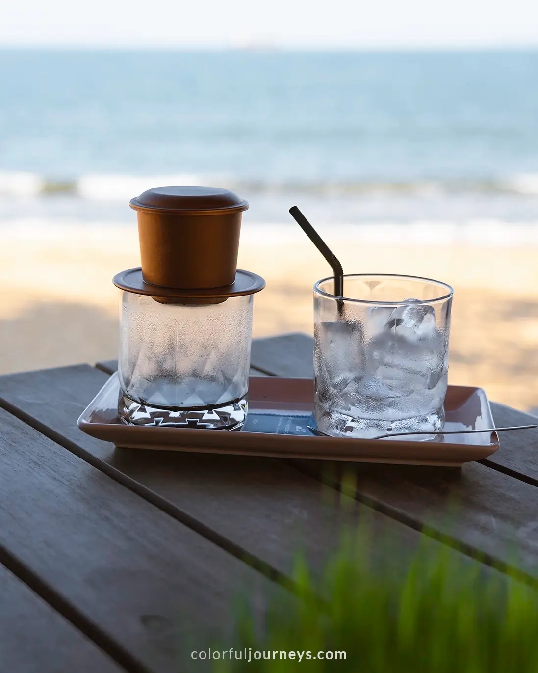 A Vietnamese drip coffee with the beach of Quy Nhon in the background