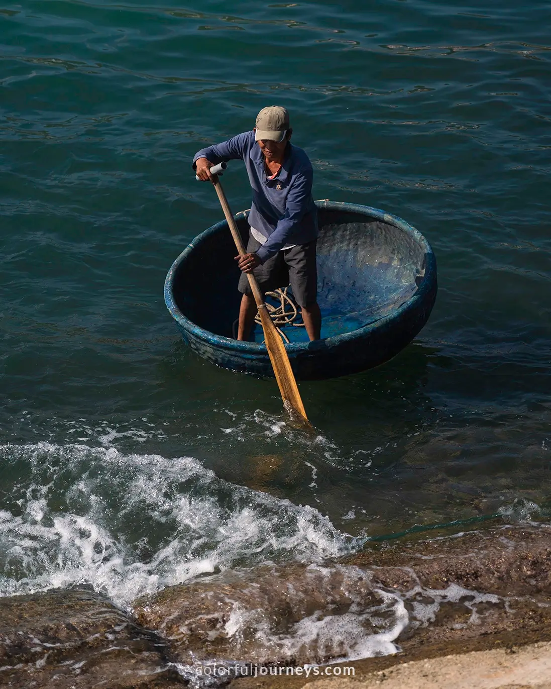 A man on a coracle boat in Nhon Ly, Vietnam