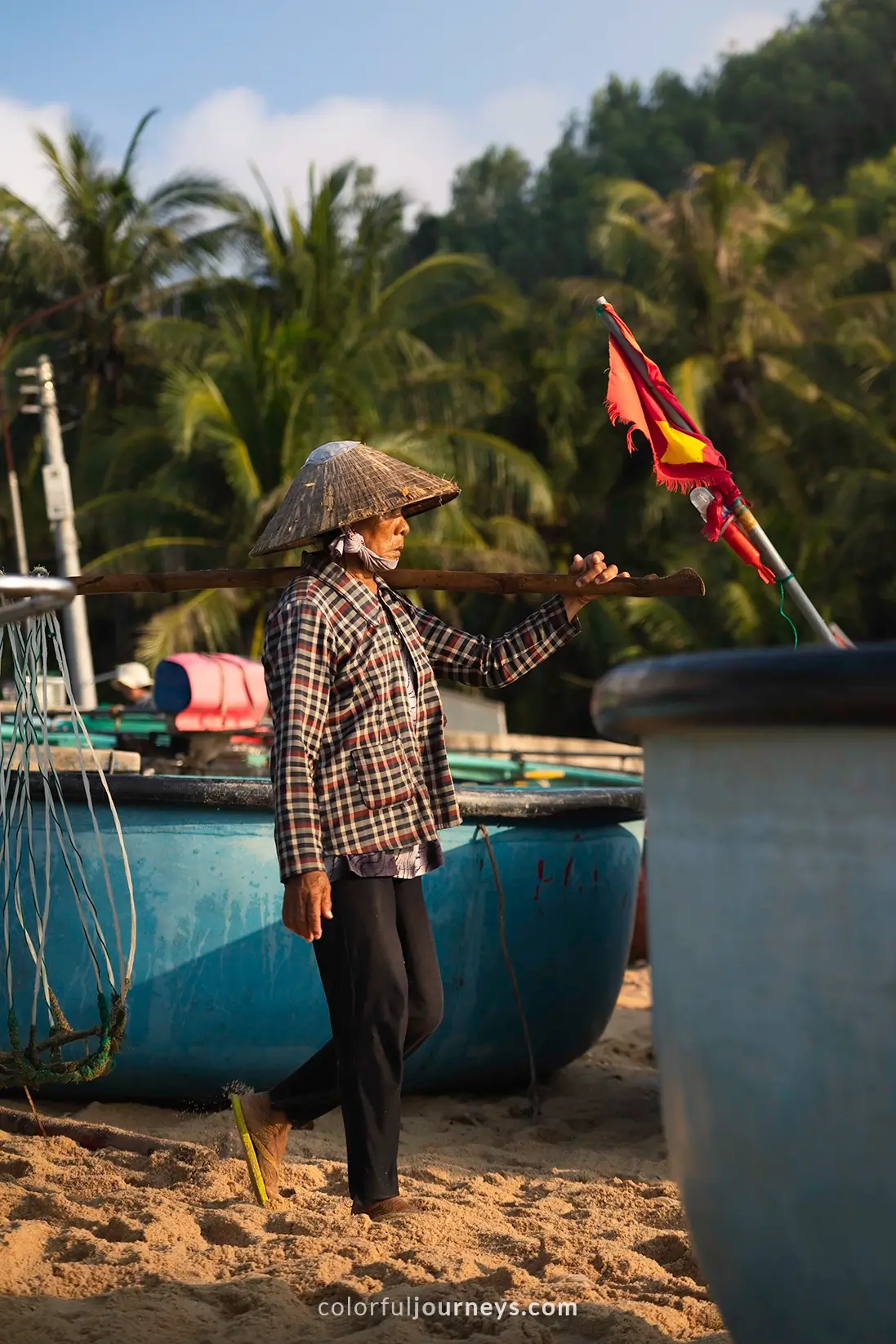 A woman wearing a conical hat at a fish market in Vietnam