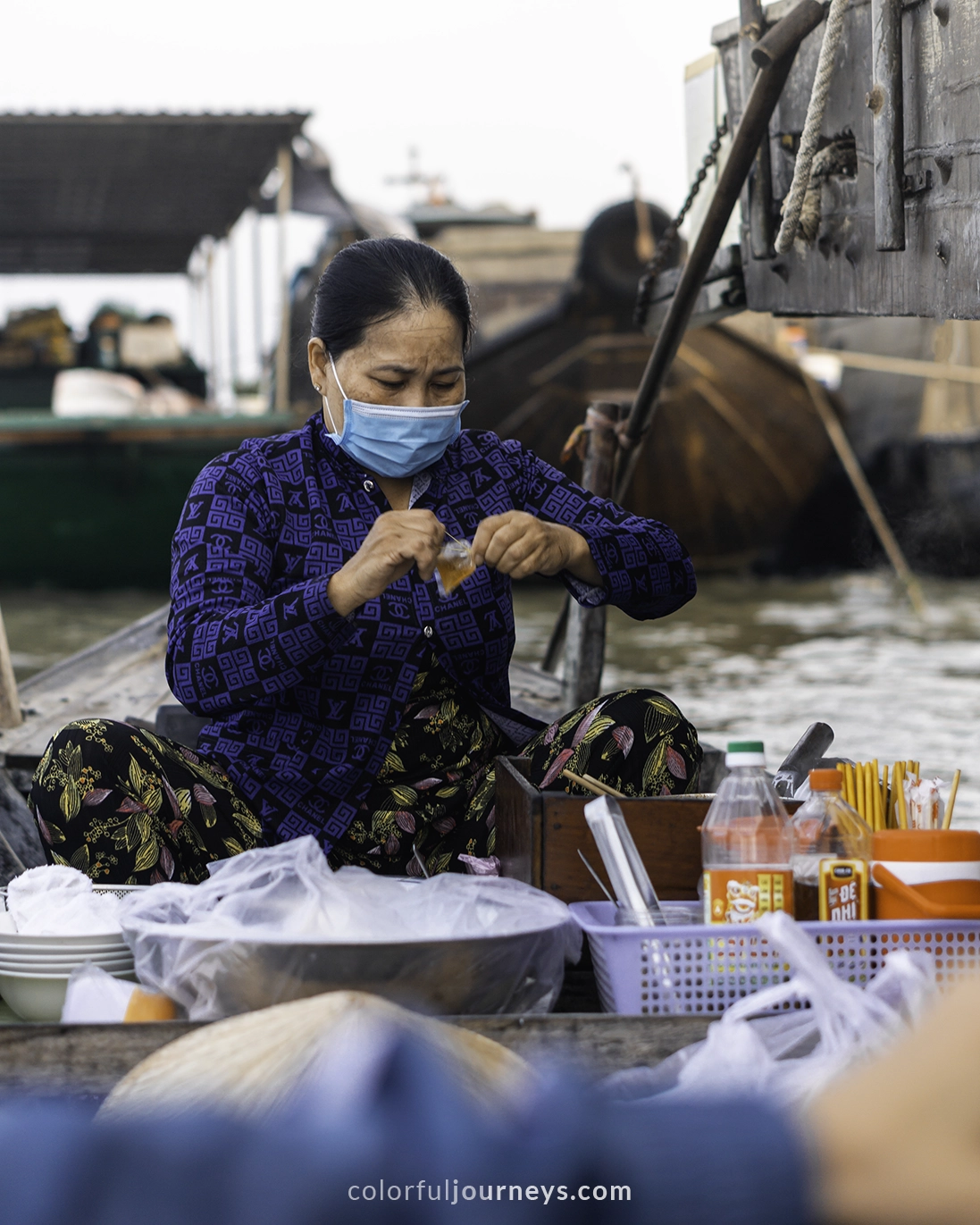 A woman sells bowls of noodles from a boat at the Long Xuyen Floating Market in Vietnam