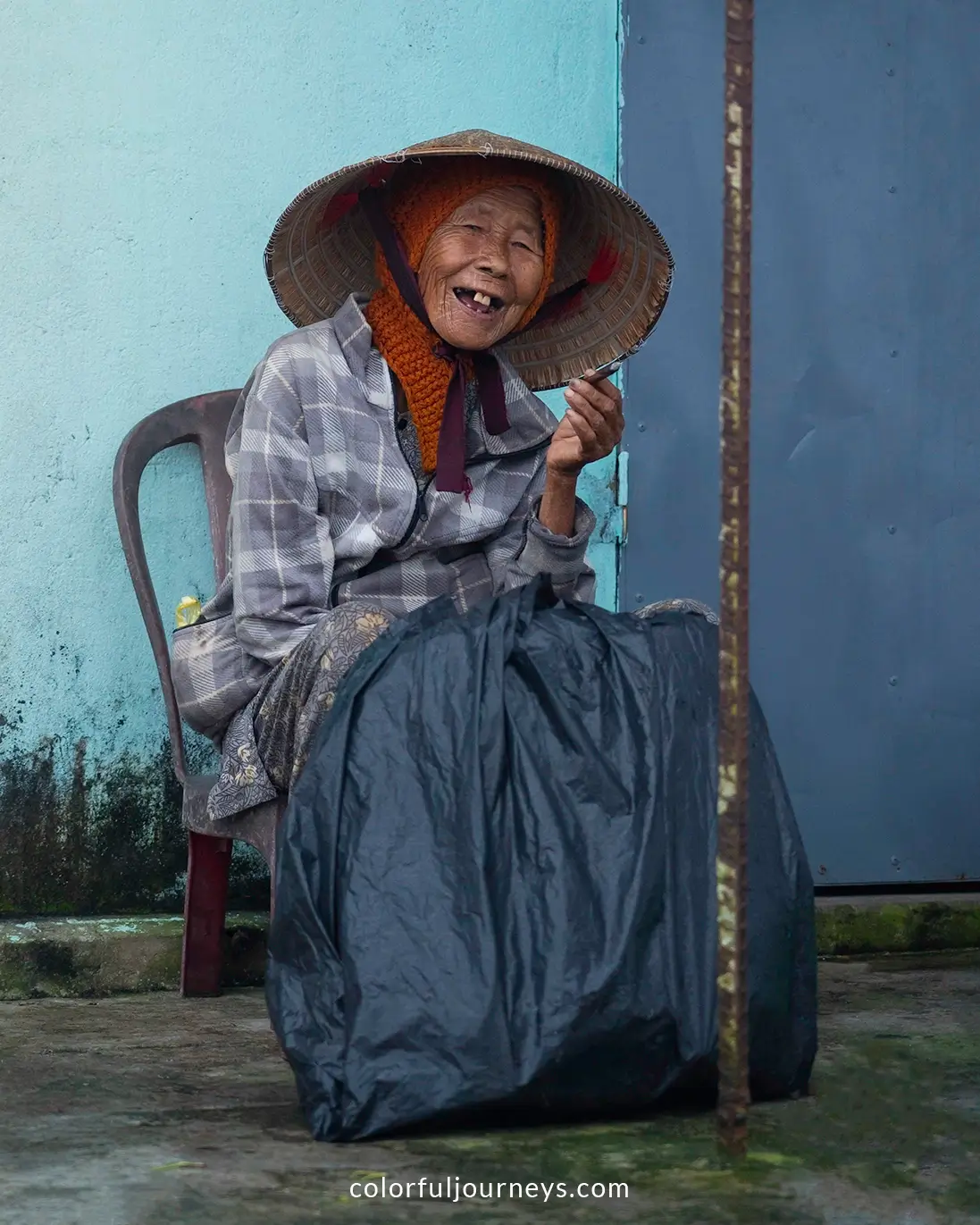 A elderly woman smiles at the camera in Hoi An, Vietnam
