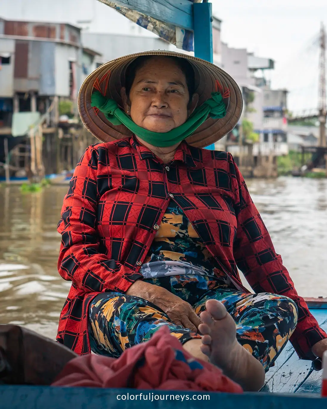 A woman wearing a conical hat on a boat in Chau Doc, Vietnam