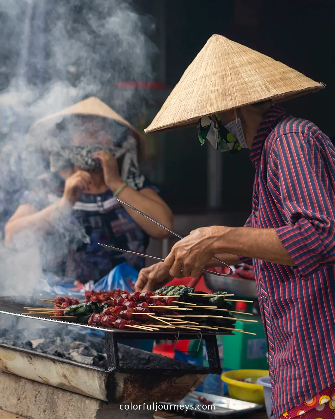Women grill sausages in Chau Doc, Vietnam