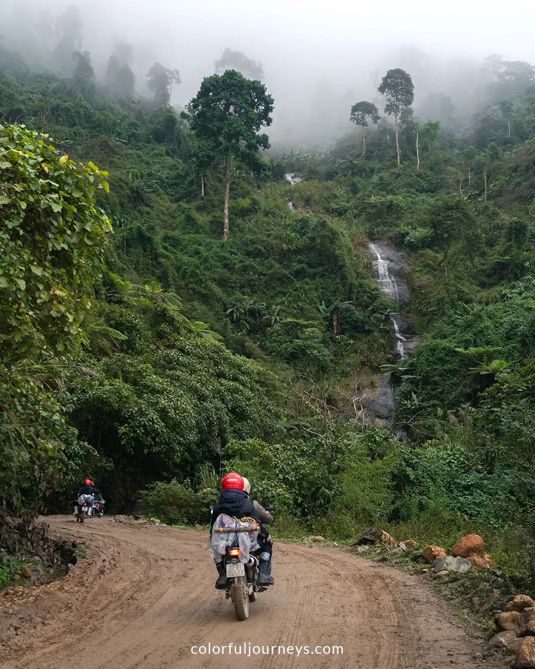 Motorbikes ride over a muddy road in northern Vietnam