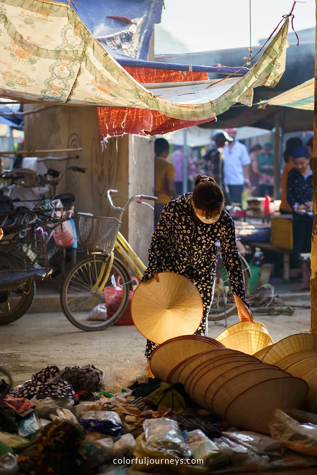A woman buys a Non La at a market in Pu Luong, Vietnam