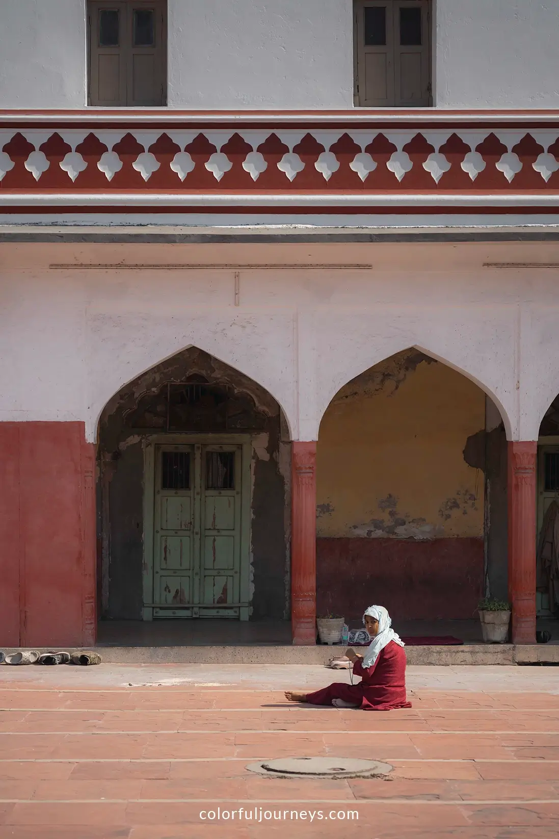 A woman sits on the ground at Fatehpuri Masjid in Delhi, India