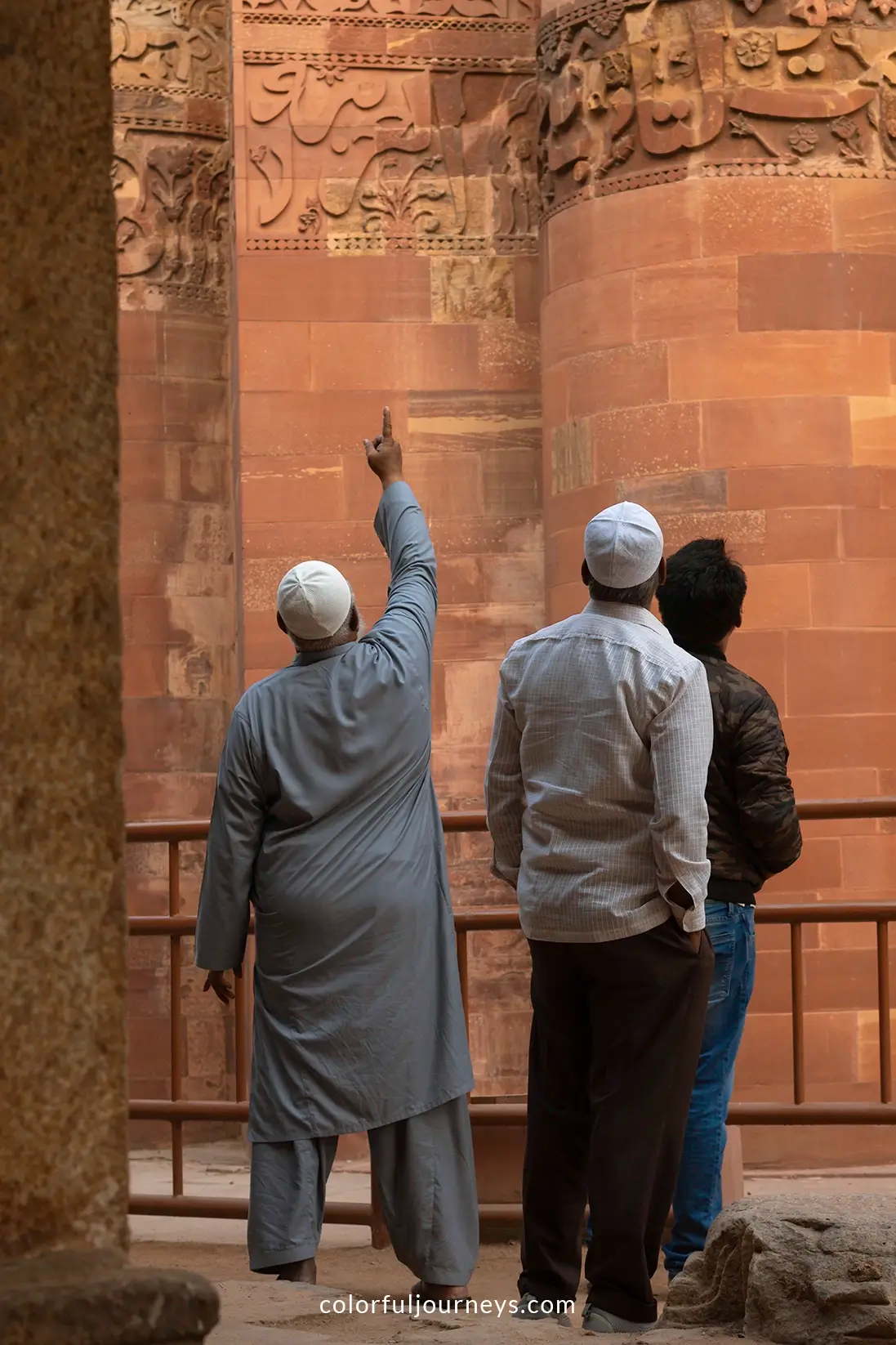 Men admire the Qutub Minar in Delhi, India