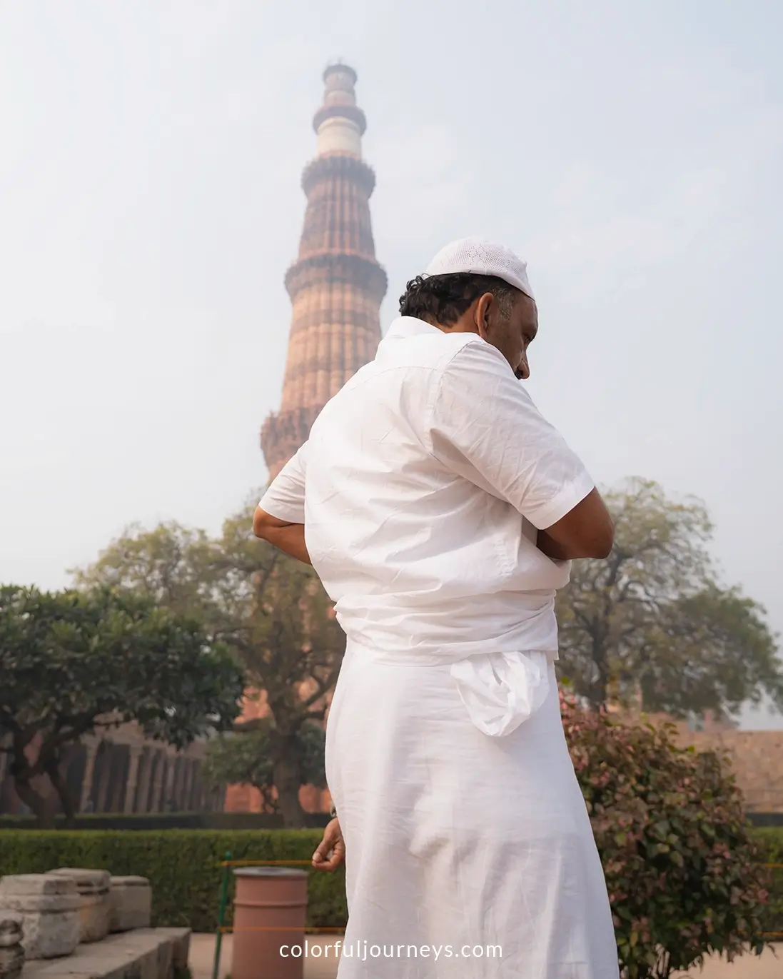 A man in front of the Qutub Minar in Delhi, India