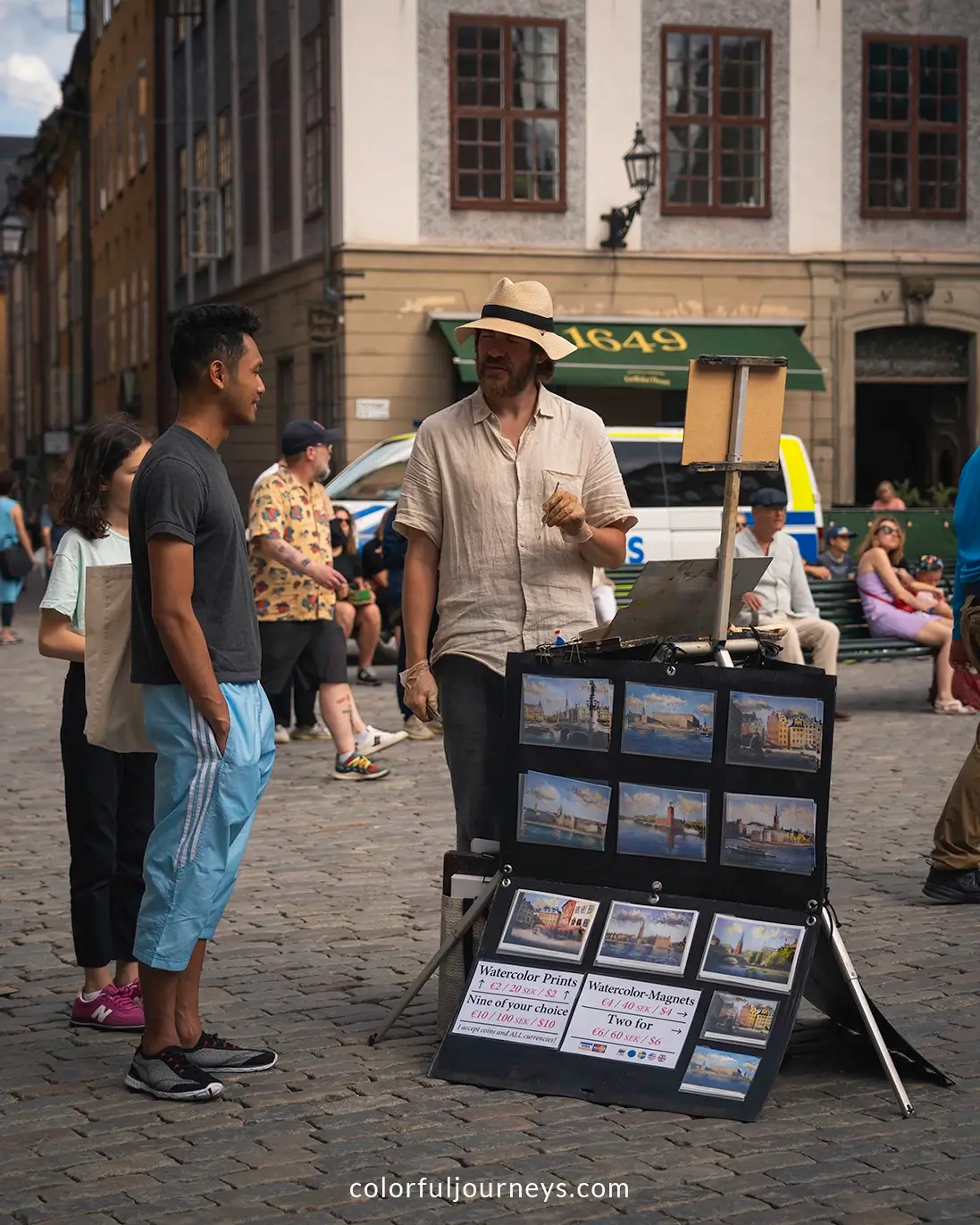 A man sells sketches on a square in Stockholm, Sweden