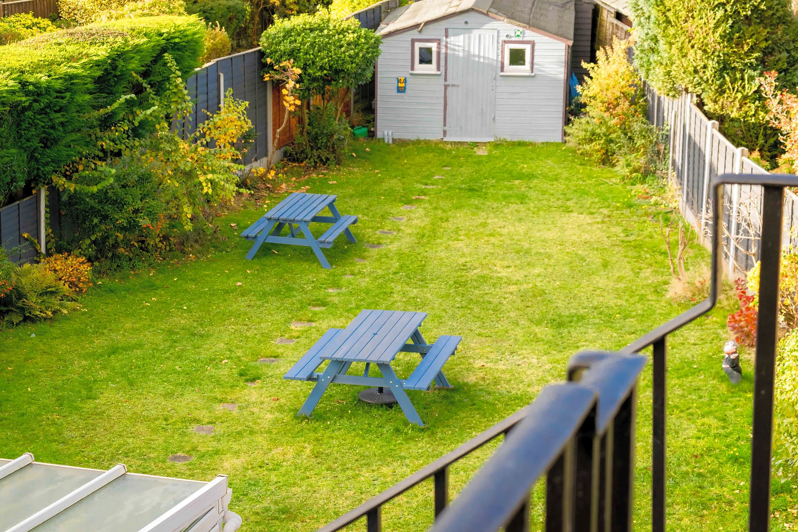 The hotel's lawned garden with blue picnic benches