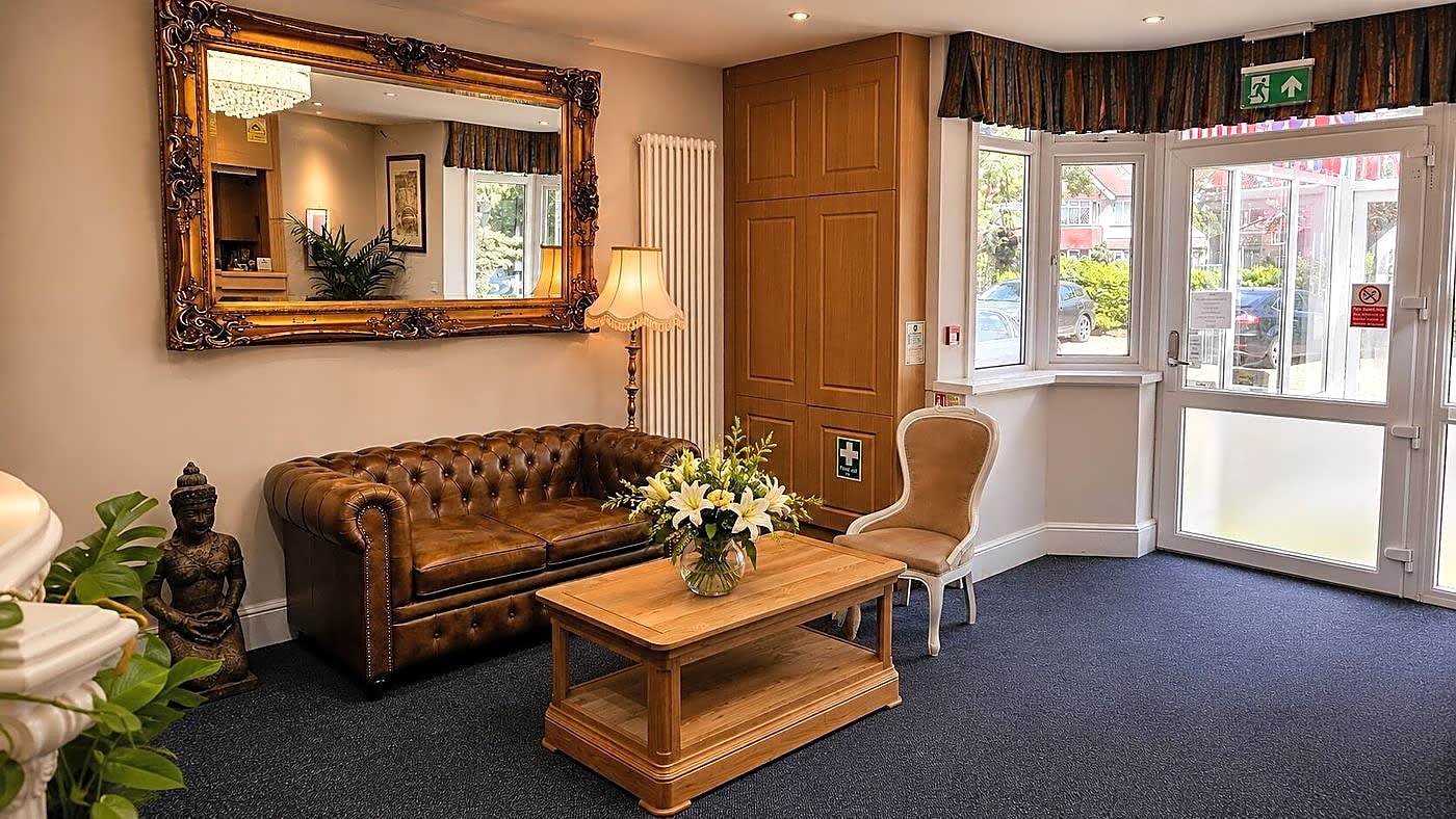 Guest lounge with a leather sofa, gilded mirror and coffee table