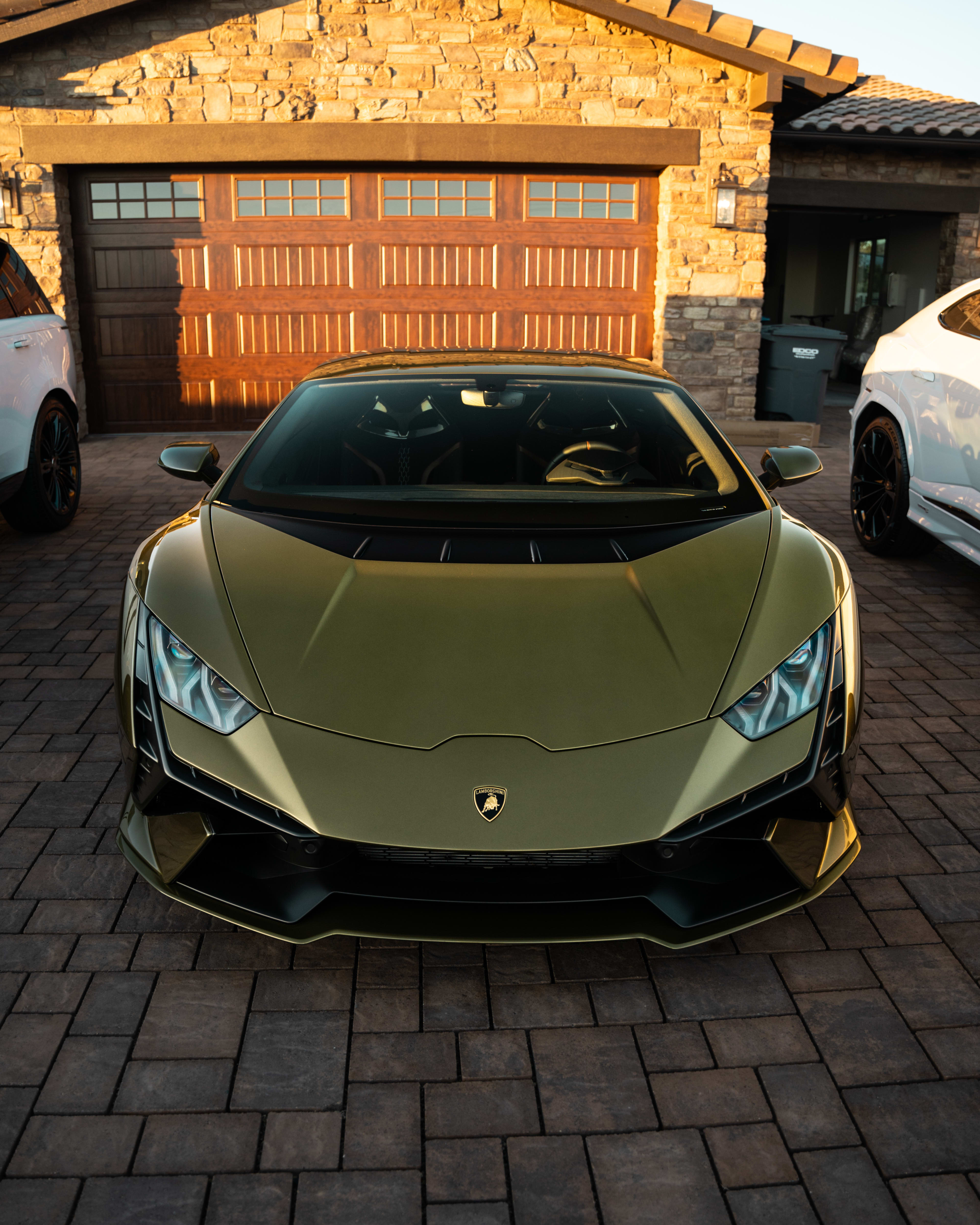 Gold Lamborghini Huracan front view at luxury estate