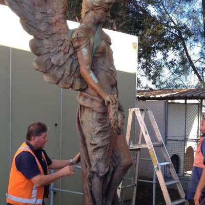 Before treatment- conservators inspect the sculpture