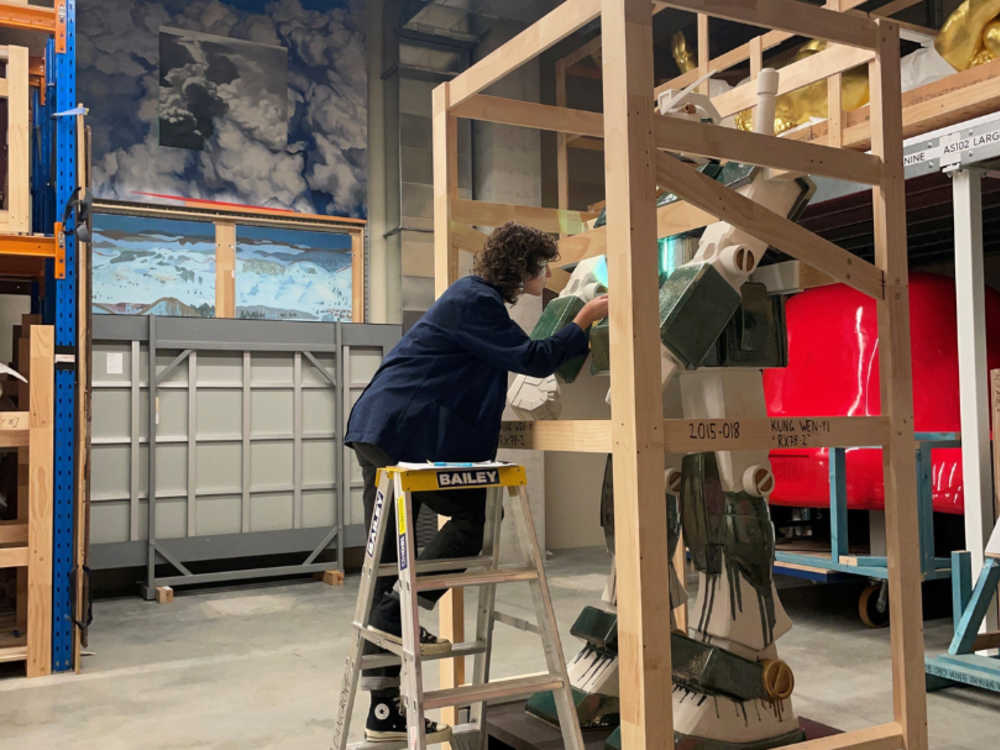 Preventive Conservator Gianna Puzzo examining RX78-2 by Kung Wen-Yi in storage