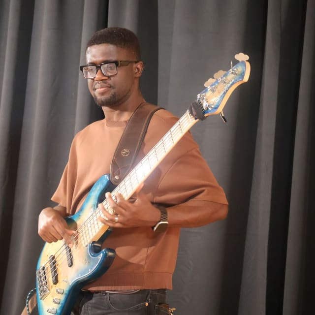 The bassist plays a blue bass guitar