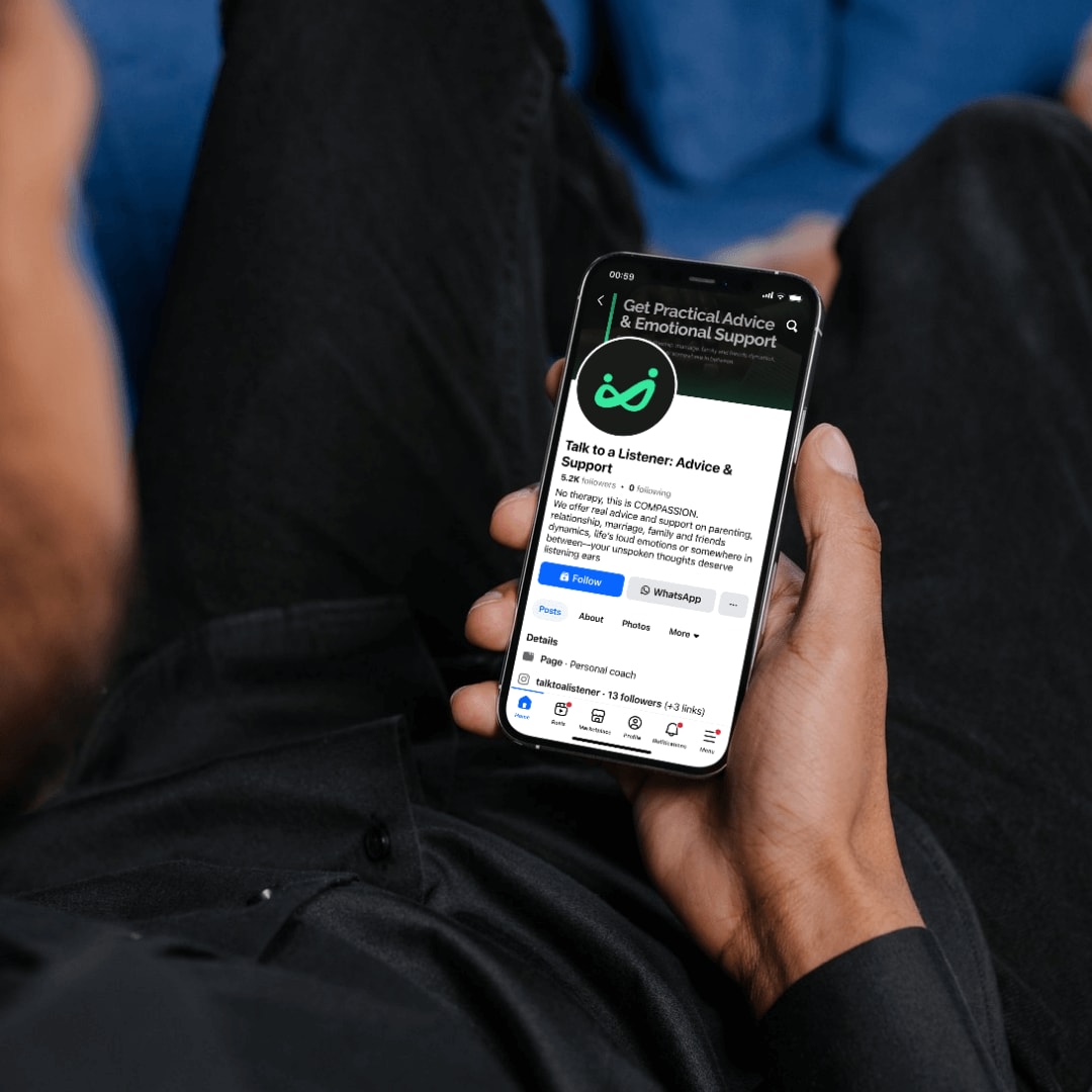 A person holds a smartphone displaying a Facebook page titled 'Talk to a Listener: Advice and Support'. The page features options to like, follow, share the page, and access appointment booking for personal support sessions.