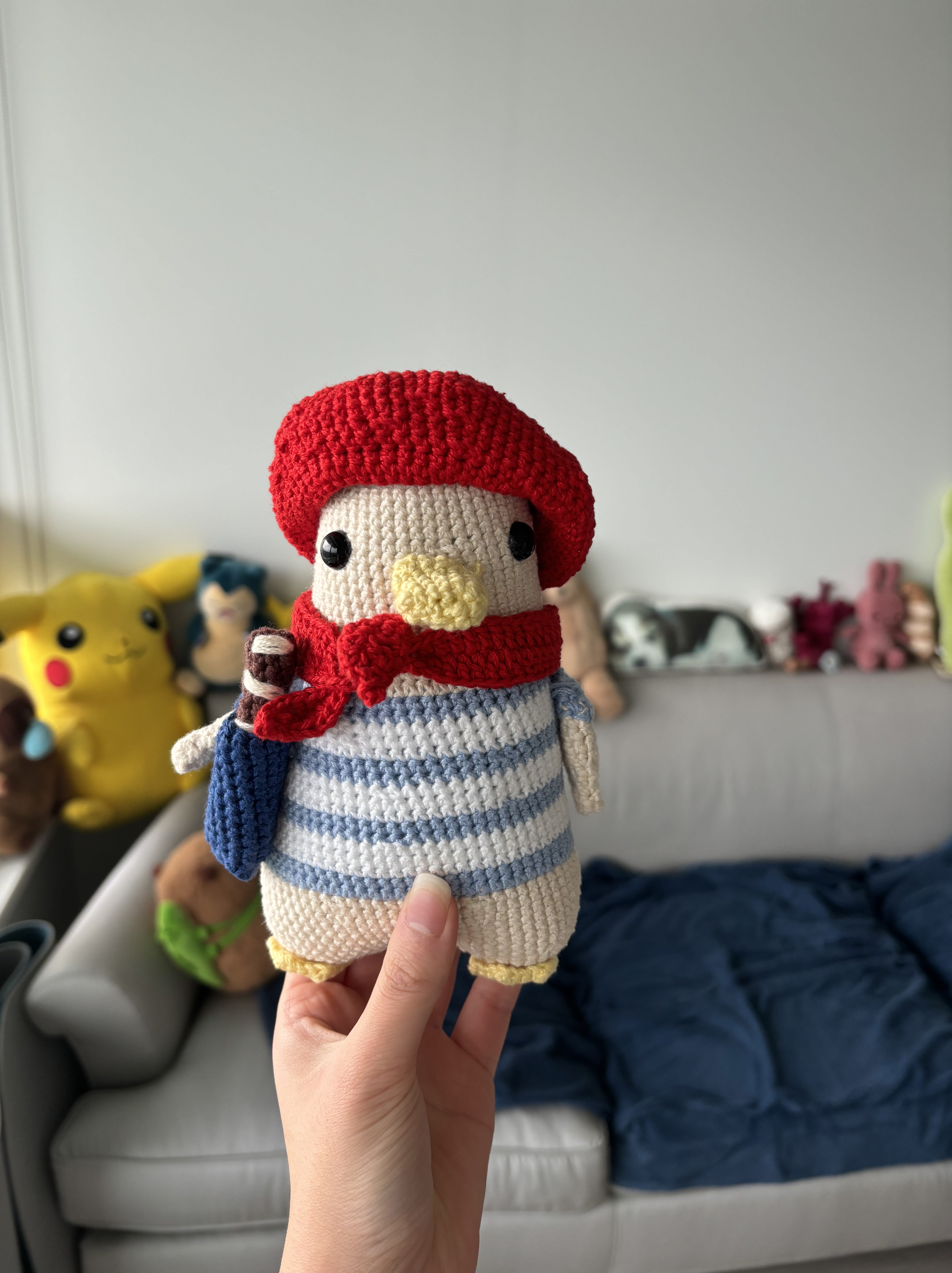 crochet creation of a french goose wearing a beret and holding a baguette