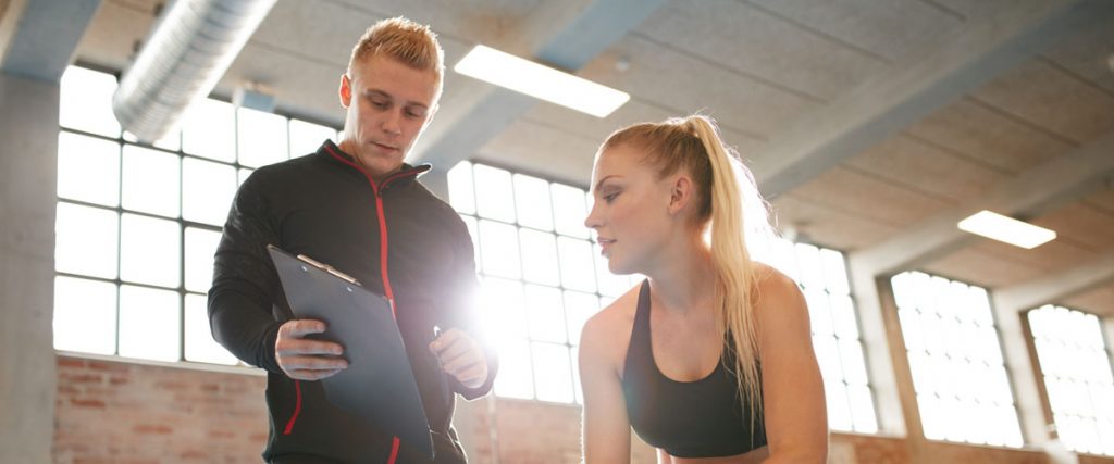 Personal Trainer with Client and Tablet - Virtuagym