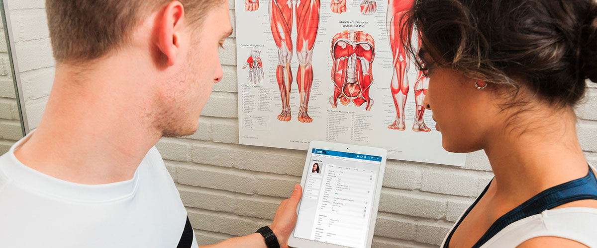 Personal trainers kijken op de Ipad met Virtuagym-app op het scherm