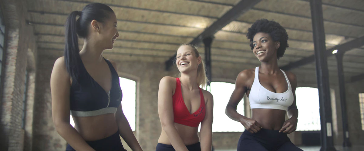 Drie vrouwen zitten in de fitnessstudio en kletsen