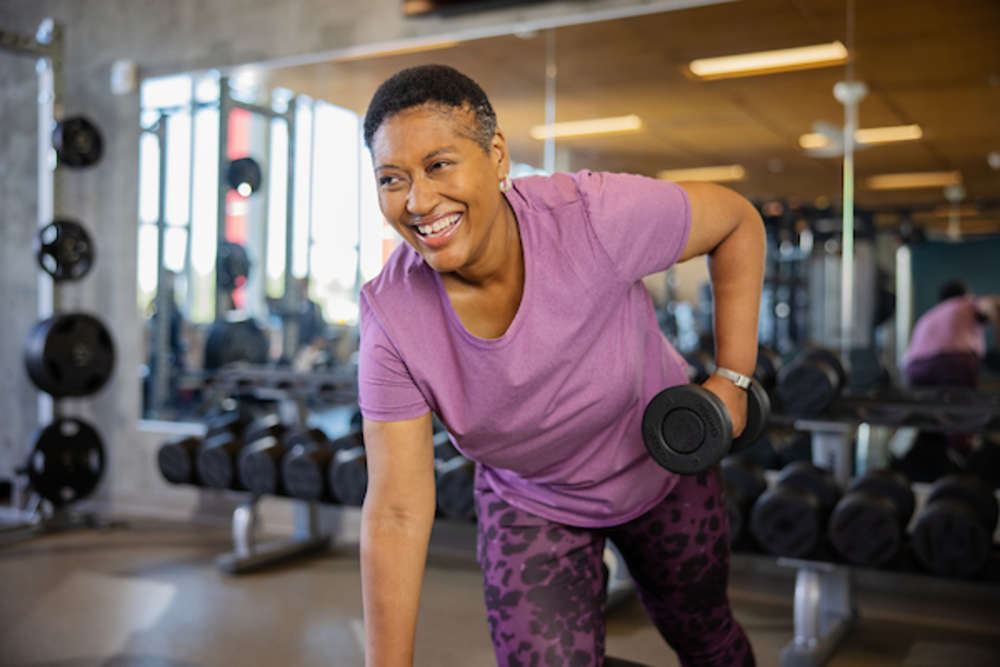 woman is doing a workout with dumbbell in the gym